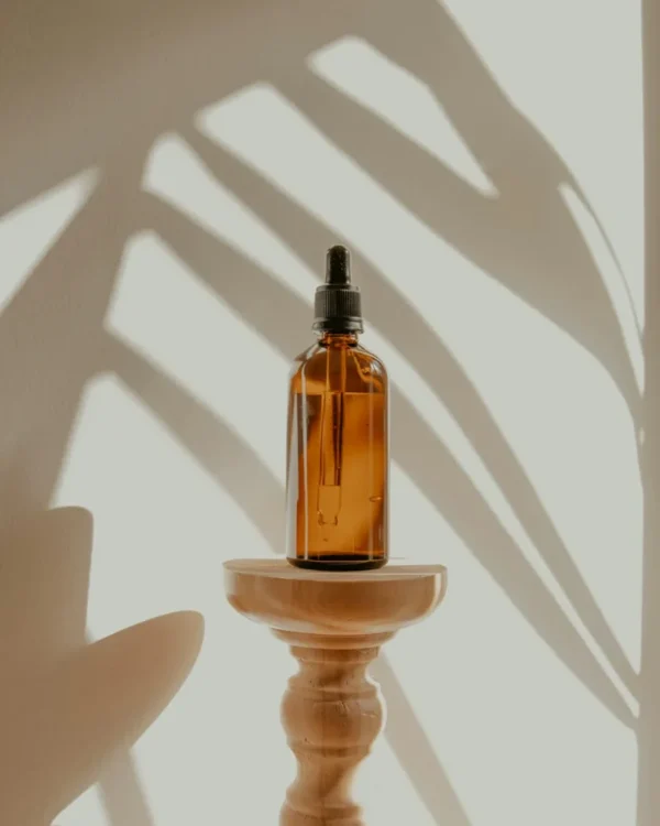 Sfeerfoto van een amberkleurige flacon in zonlicht; niet het demoproduct